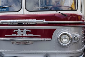 A vintage black-and-white photo of the first Vishkarma bus from 1953 parked outside a bustling Delhi street.