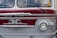 A vintage bus with a distinctive front design, featuring an emblem and retro headlights. The bus has a two-toned color scheme with maroon and silver hues and chrome accents. Visible portions of the interior show the steering wheel and a partial view of a person inside.