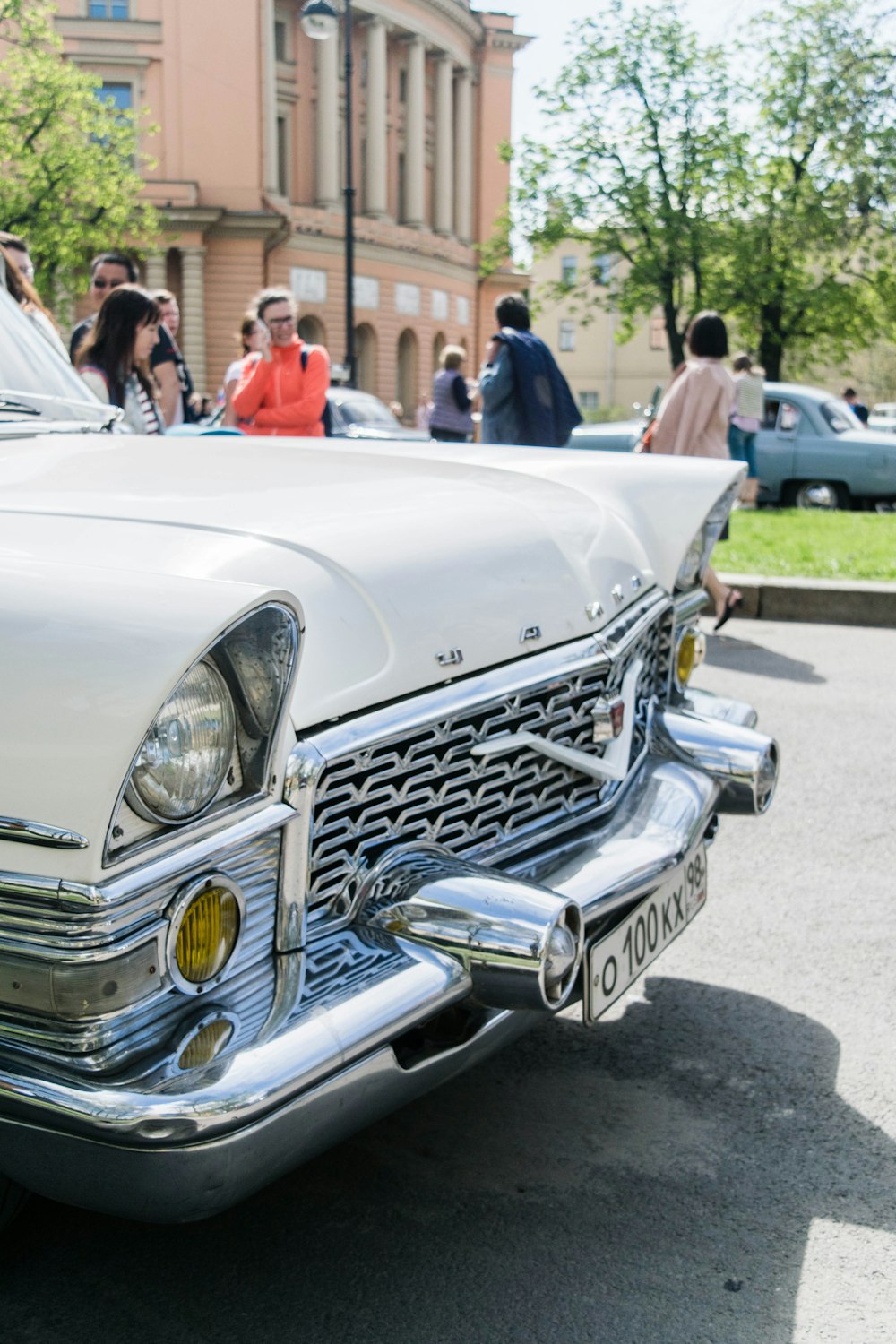 a white classic car parked on the side of the road