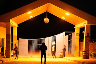 Nighttime view of a secure gated entrance with modern surveillance cameras.