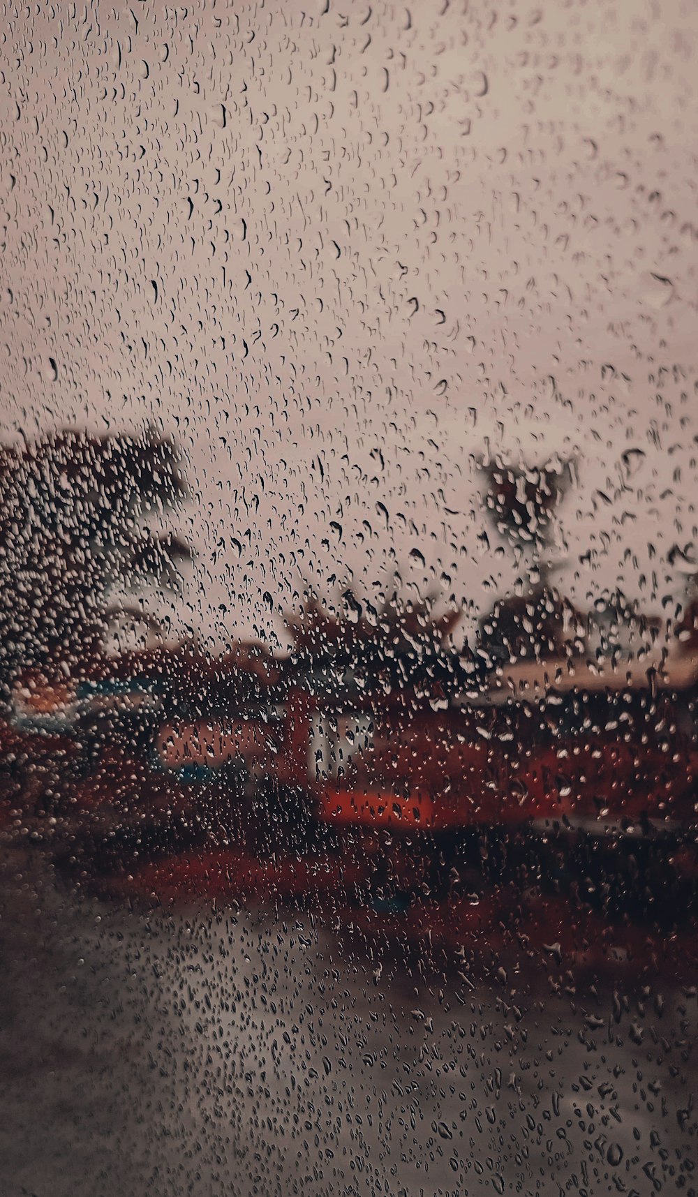 Una vista de un edificio a través de una ventana cubierta de lluvia