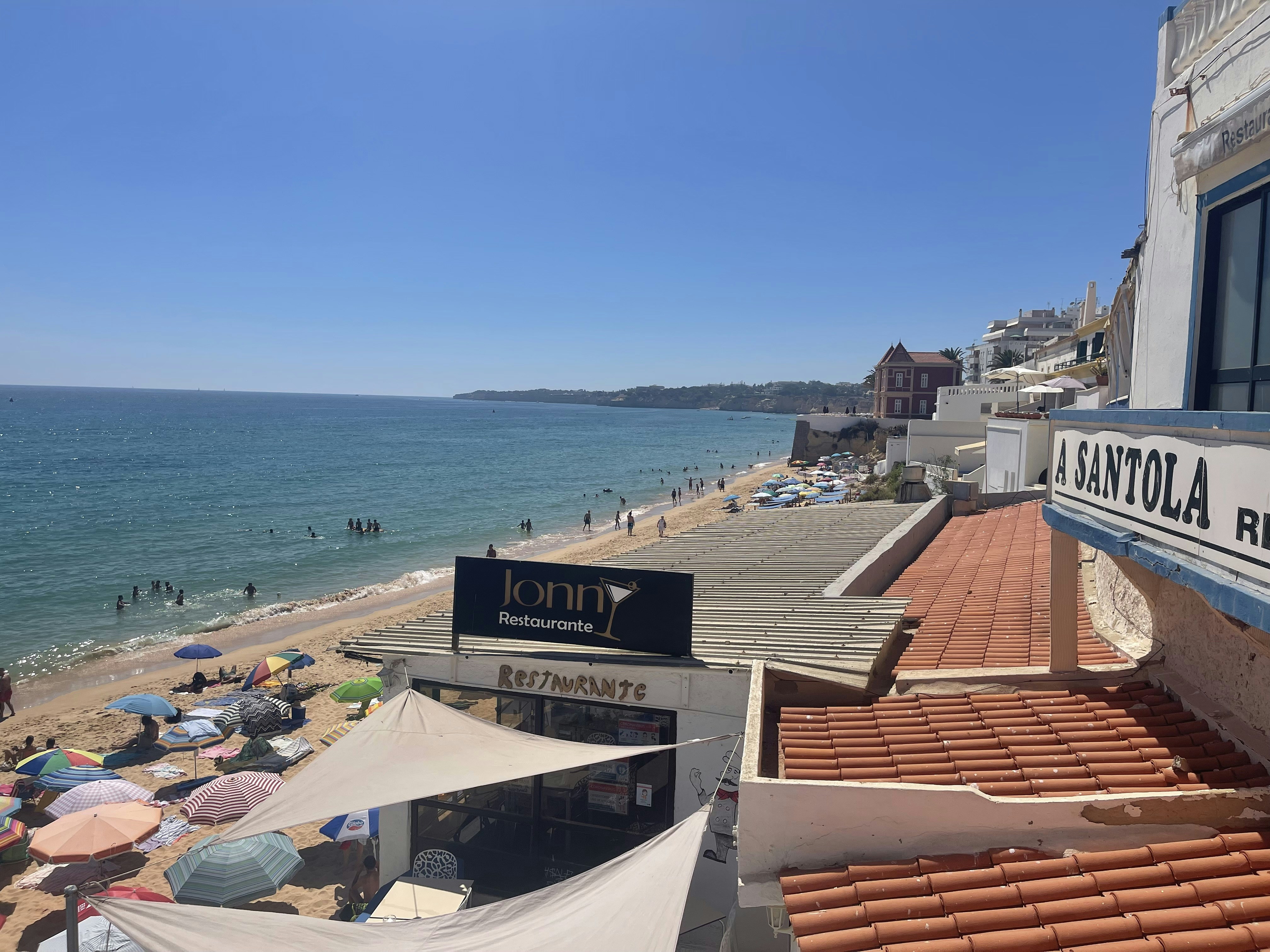 a beach with a lot of people and umbrellas
