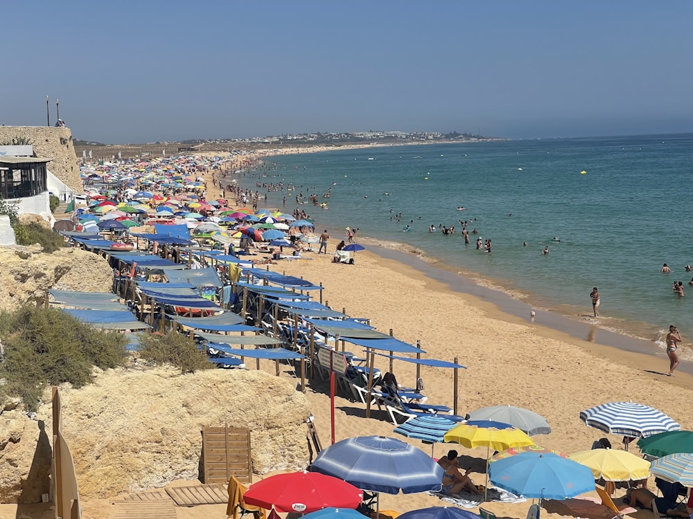 a beach filled with lots of people and umbrellas