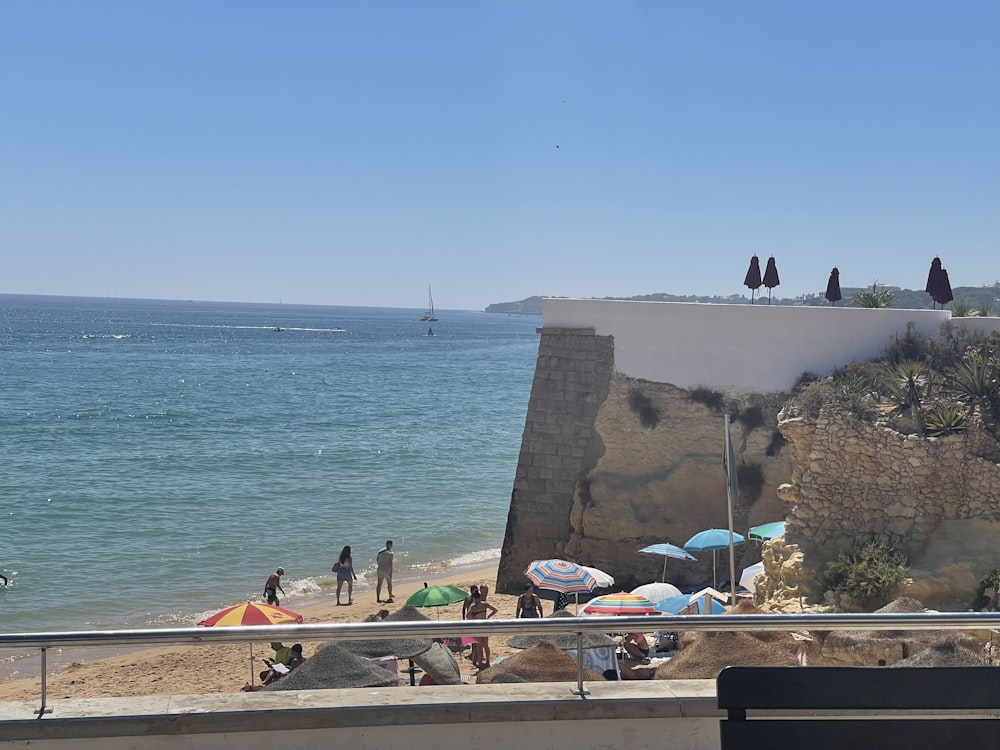 a group of people standing on top of a beach next to the ocean