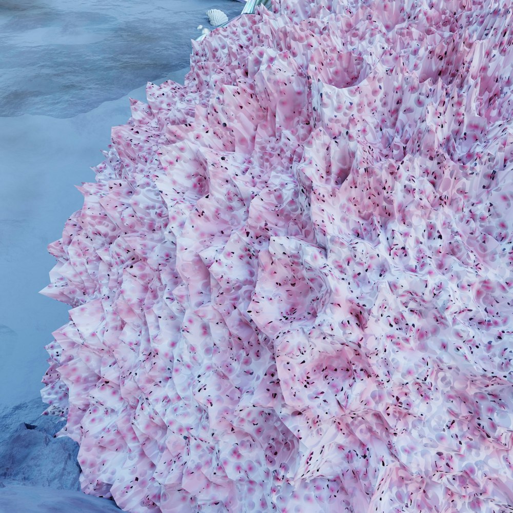a pink and white blanket sitting on top of a snow covered ground