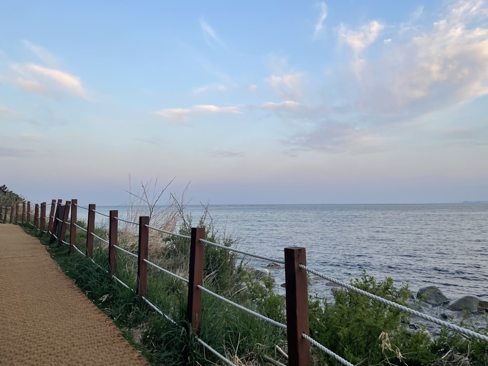 a path next to the ocean leading to a beach