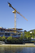 a large crane is on top of a building next to a body of water