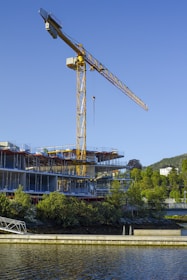 a large crane is on top of a building next to a body of water