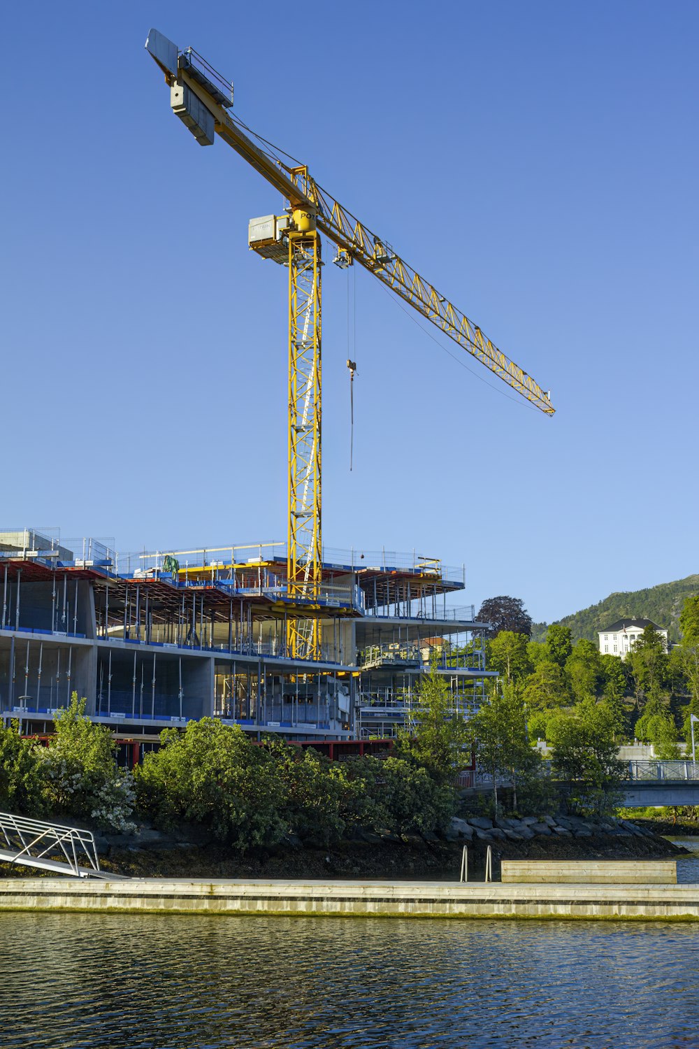 a large crane is on top of a building next to a body of water