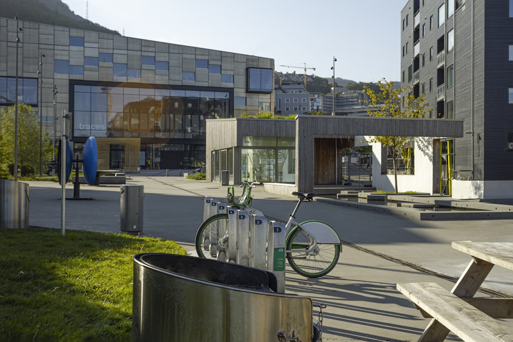 un vélo garé à côté d’une poubelle en métal