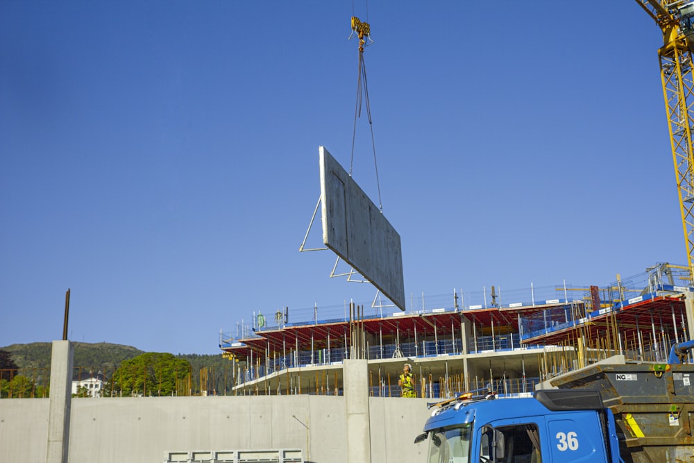 a crane is lifting a large sign onto a building