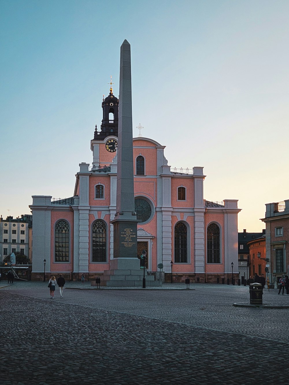 a pink building with a clock tower in front of it