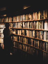 A scholar carefully examining aged documents in a quiet library.
