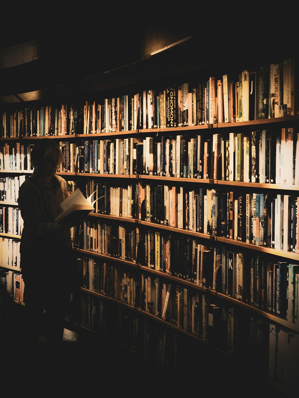 a person standing in front of a book shelf filled with books