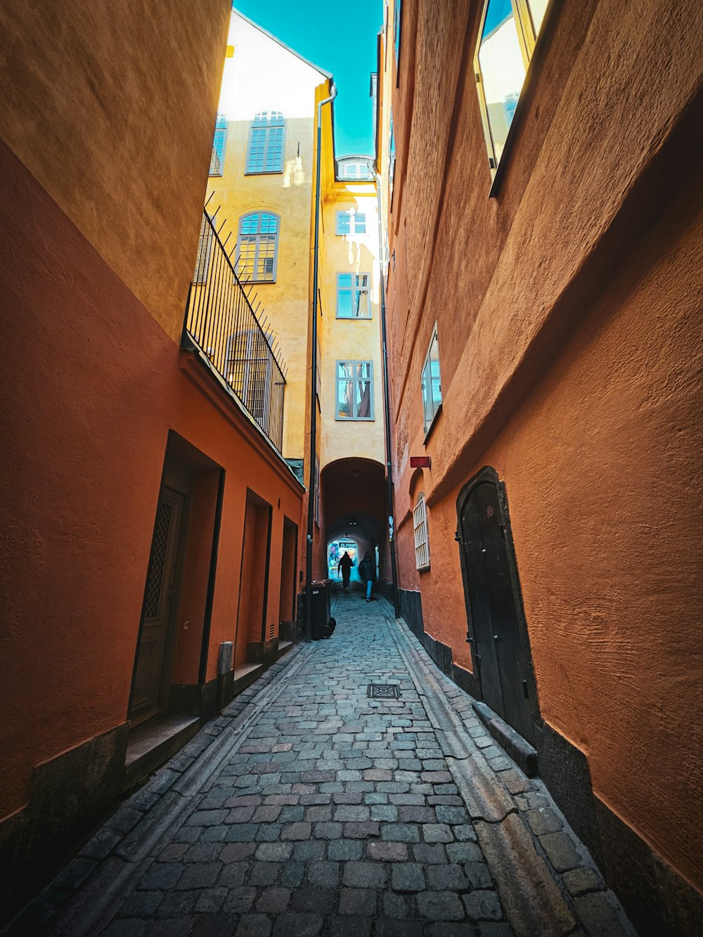 a narrow alley way with people walking down it