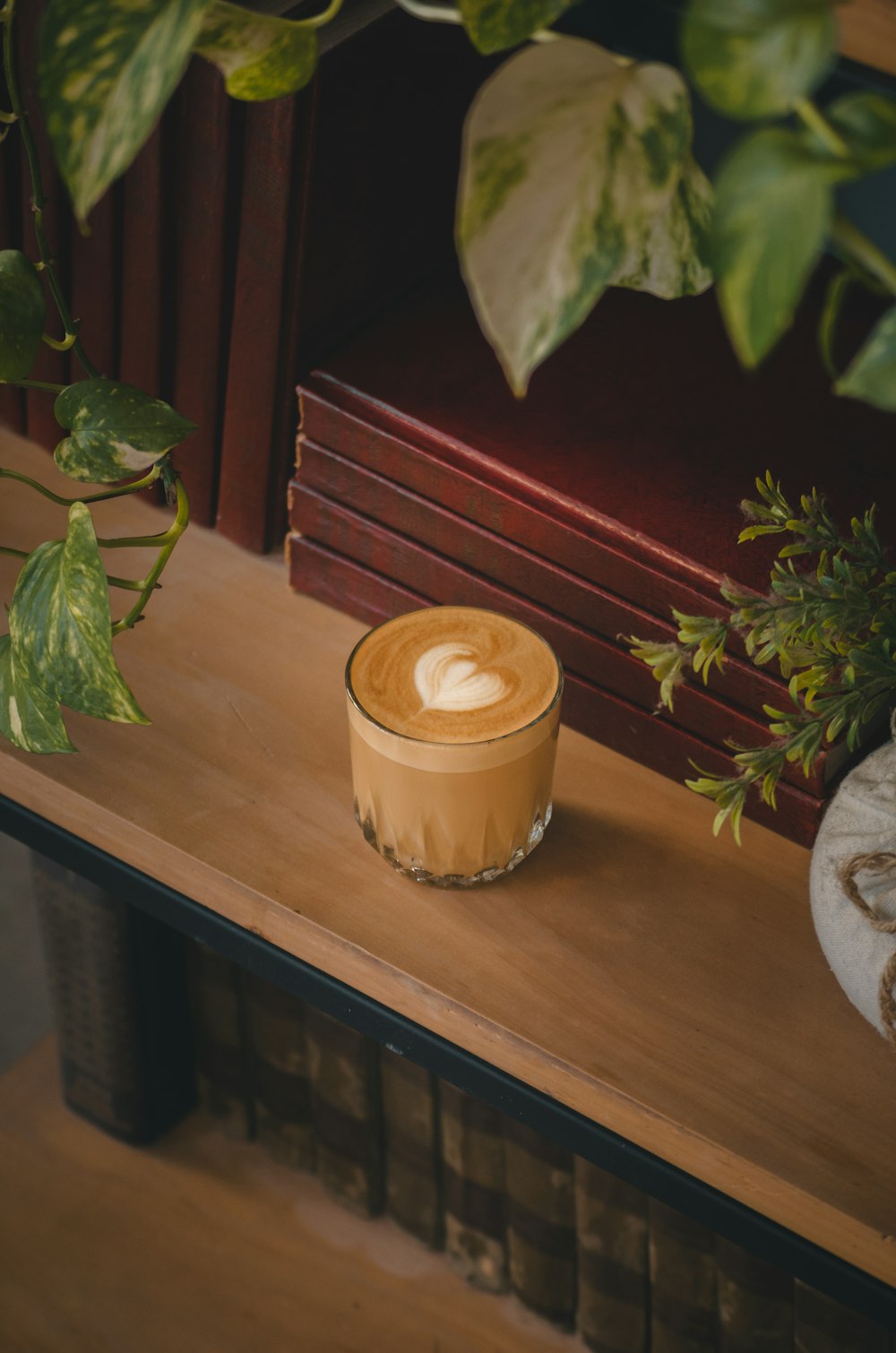 a cup of coffee sitting on top of a wooden table