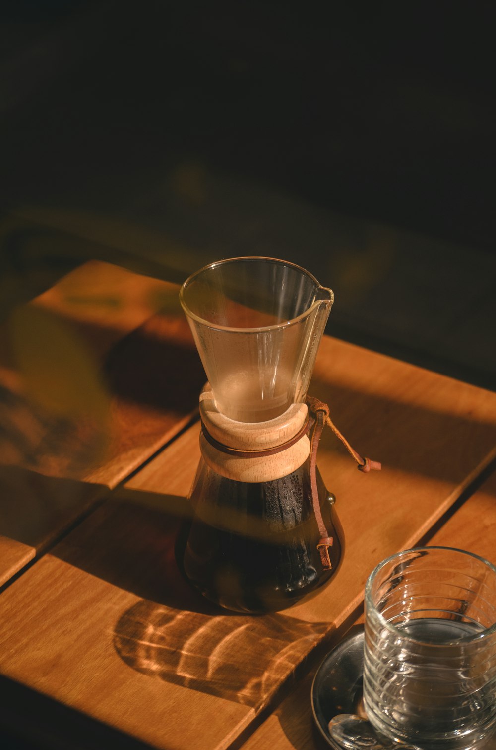 a wooden table topped with a glass of water