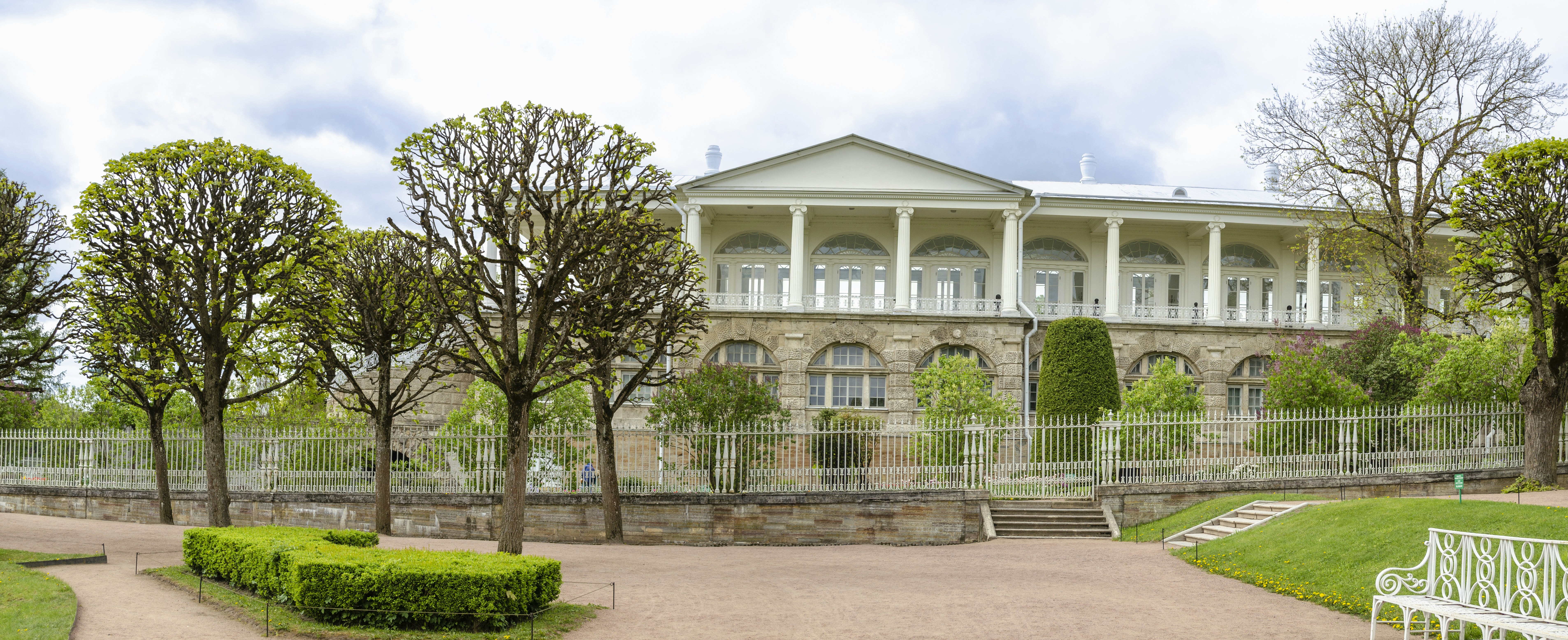 a white bench sitting in front of a large building