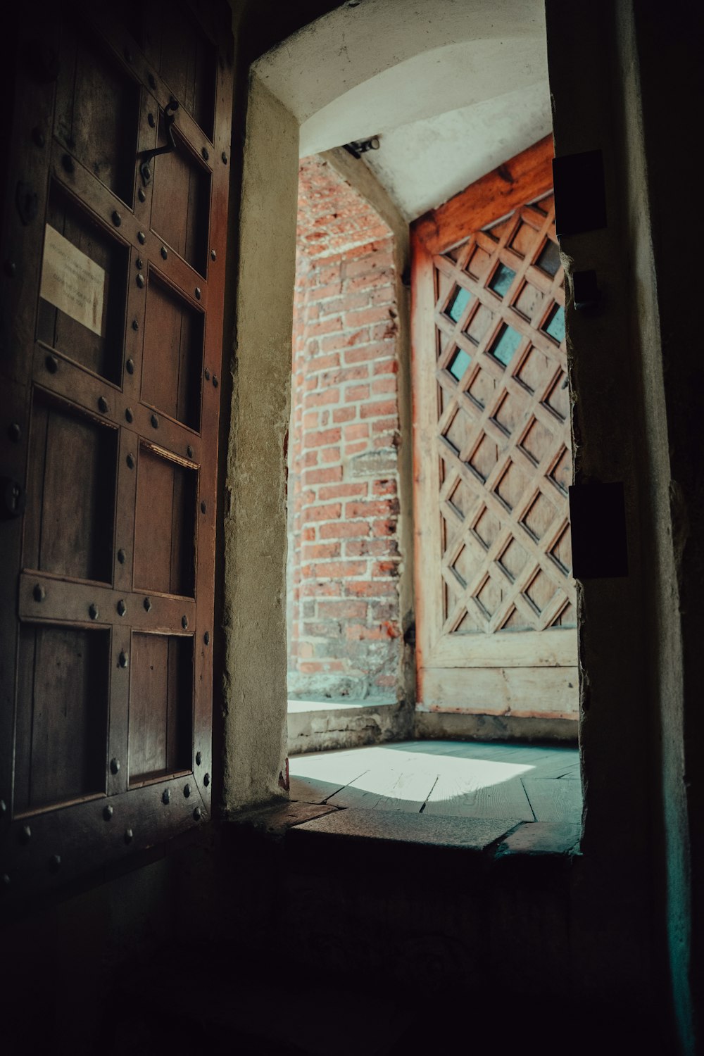 an open door with a brick wall in the background