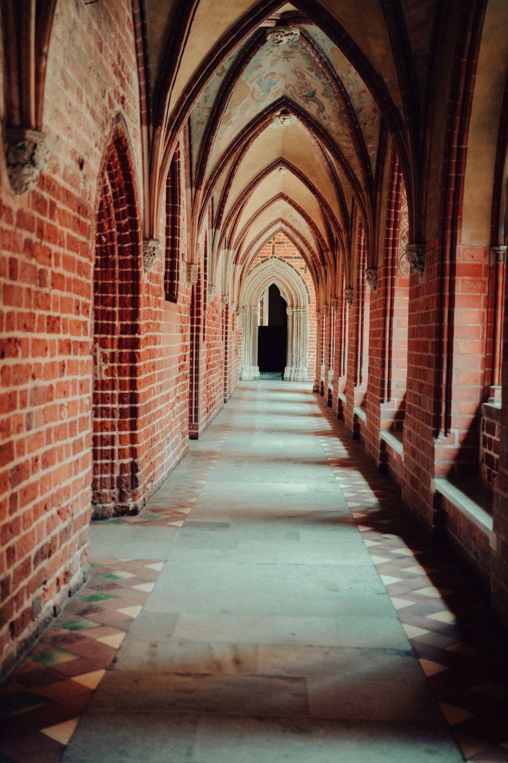 a long hallway with brick walls and arches