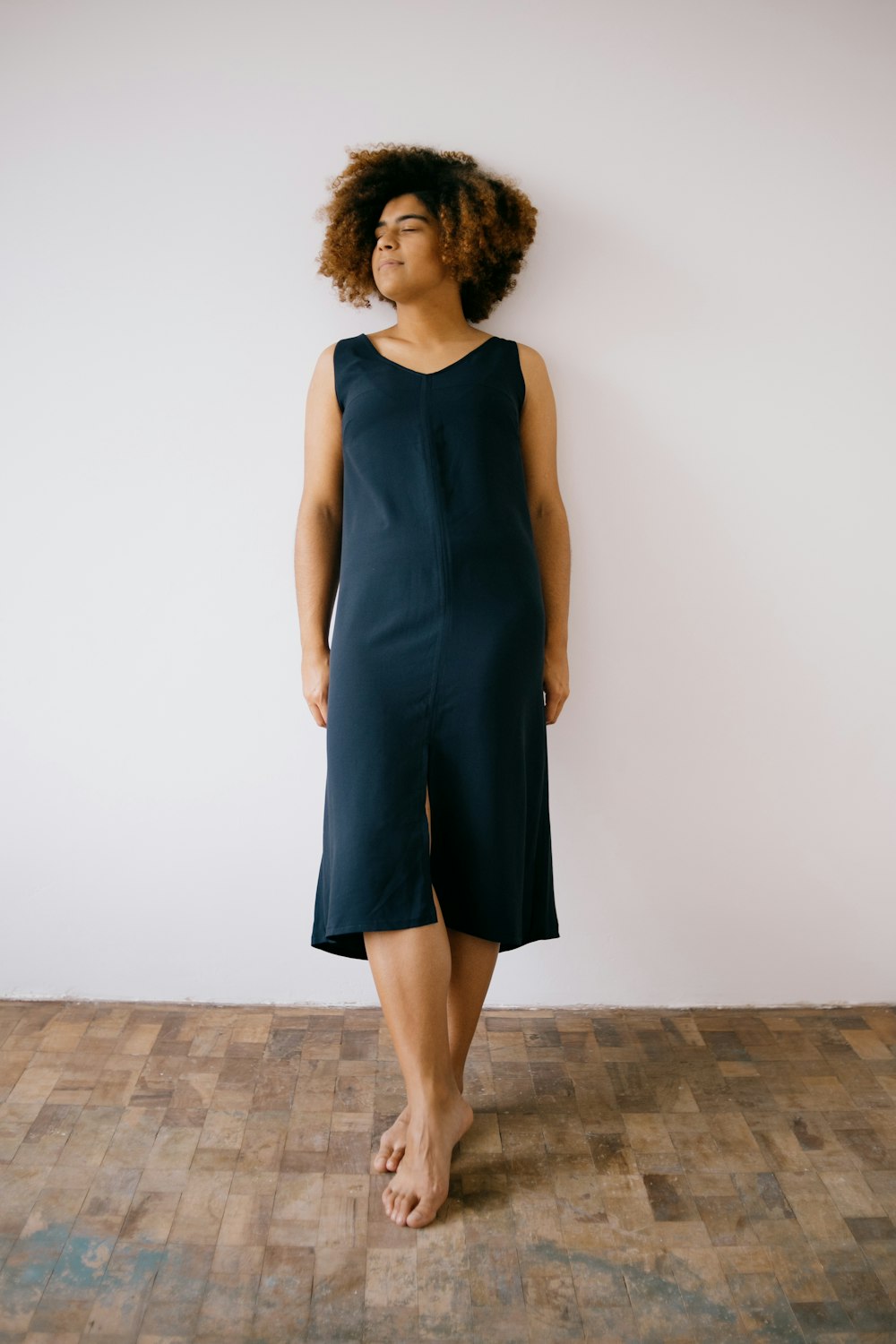 a woman standing in front of a white wall