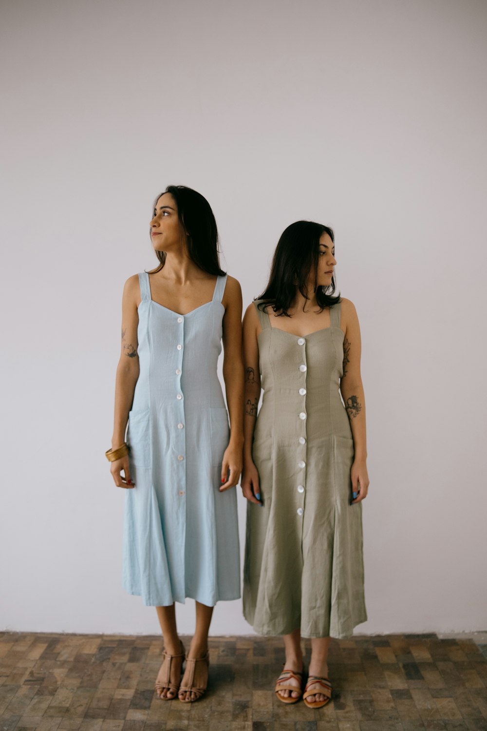 two women standing next to each other on a wooden floor