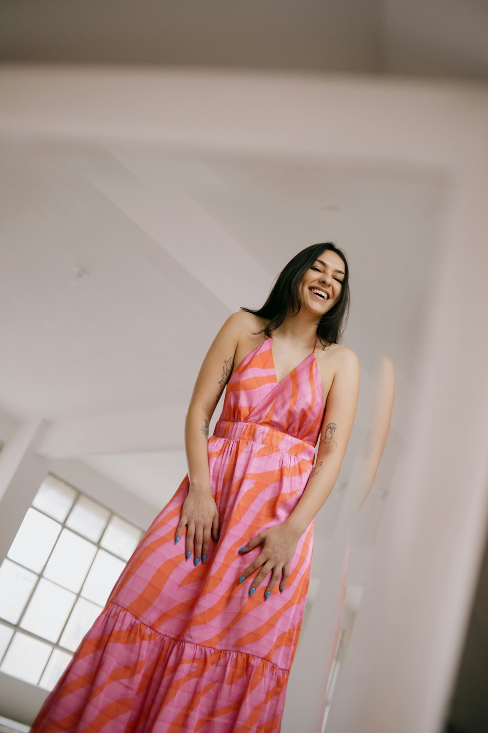 a woman in a pink and orange striped dress