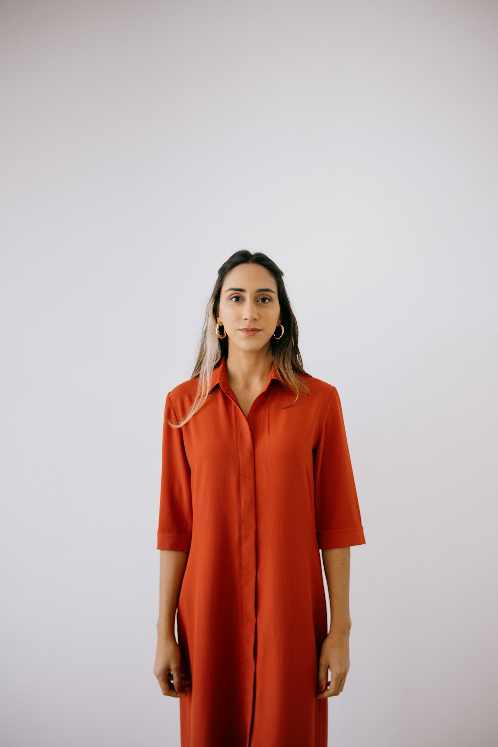 a woman wearing an orange shirt dress