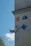 A wall is adorned with various artistic designs and graphics, including a depiction of a stylized face, a cartoon character in blue, and a relief sculpture of an angelic face with wings. There's also an abstract pattern on a blue square plaque.
