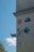 A wall is adorned with various artistic designs and graphics, including a depiction of a stylized face, a cartoon character in blue, and a relief sculpture of an angelic face with wings. There's also an abstract pattern on a blue square plaque.