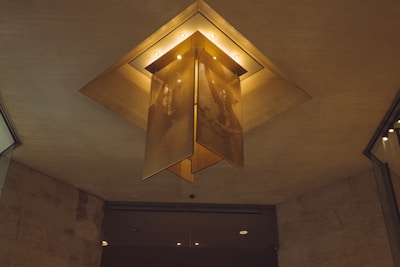 An artistic ceiling fixture blending metal and glass, creating a dynamic light pattern.