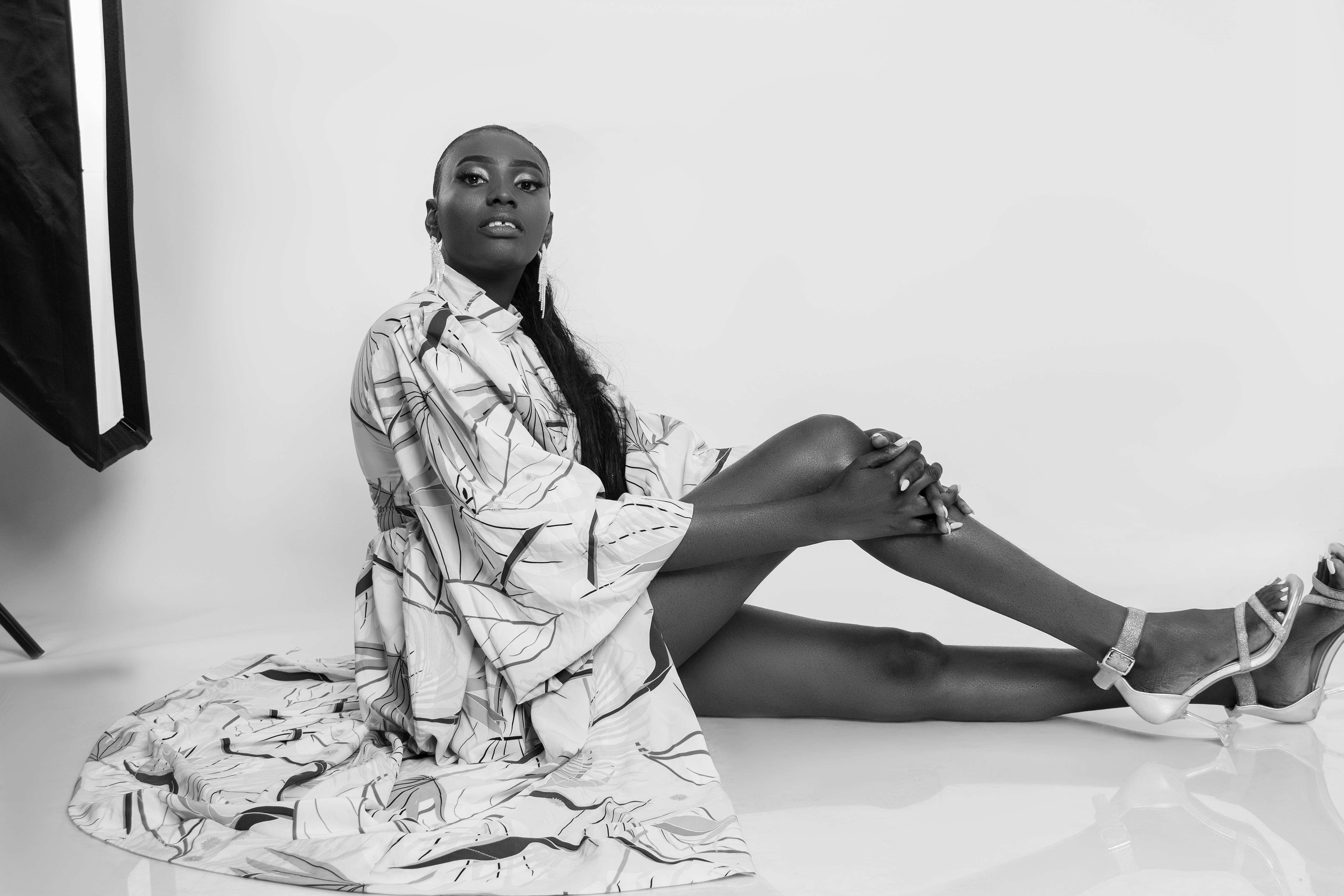 A black woman in a patterned robe and heels