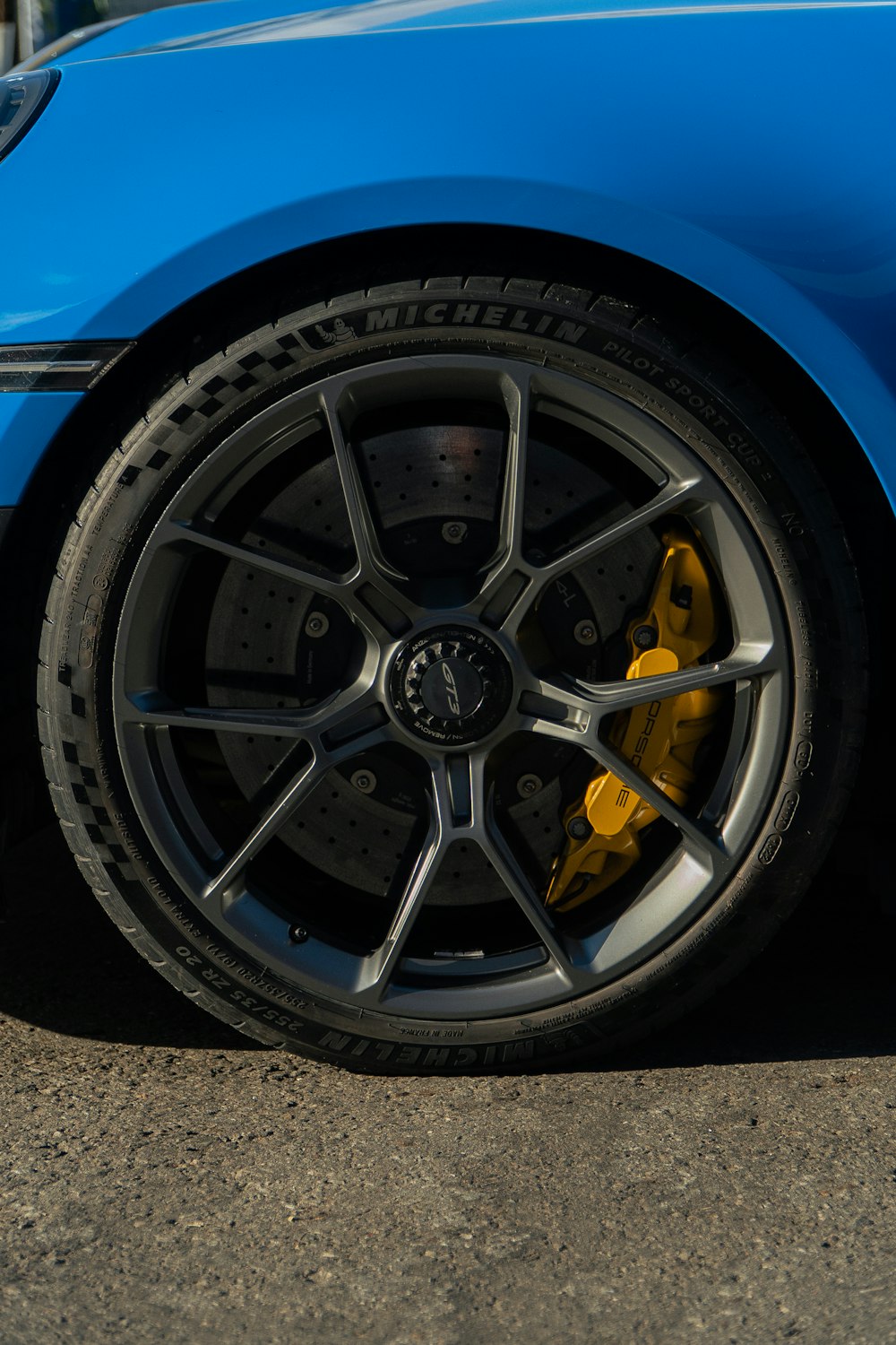a blue sports car with yellow brake pads