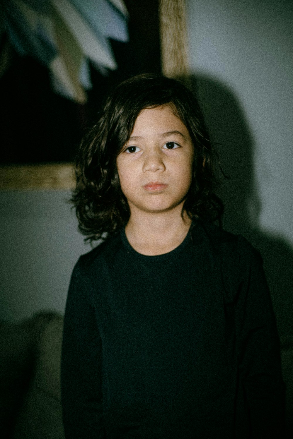 a young girl standing in front of a painting