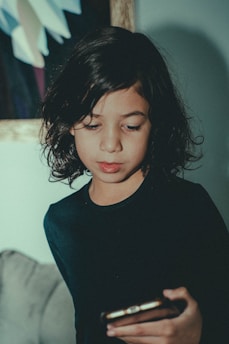 a young girl looking at her cell phone