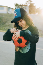 a young girl is holding a soccer ball