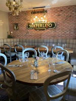 Cozy wooden dining chairs arranged around a rustic table in a charming independent restaurant.