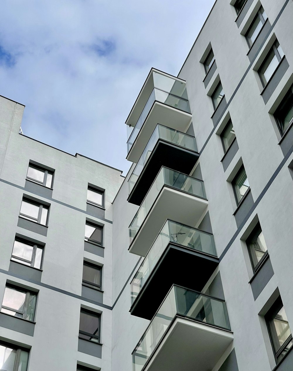 a tall white building with balconies and windows