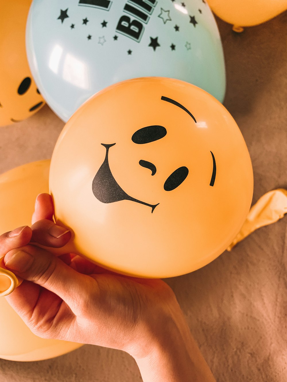 a person holding a balloon with a smiley face on it