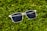 Close-up of sporty sunglasses resting on a running track under bright sunlight.