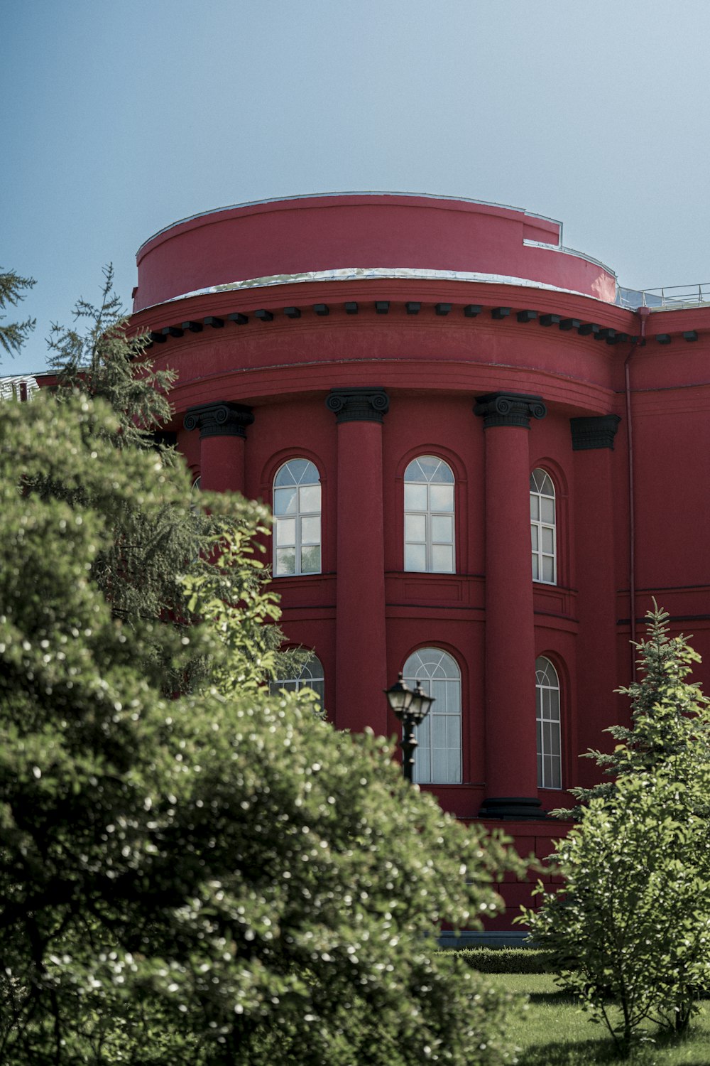 a large red building surrounded by trees and bushes