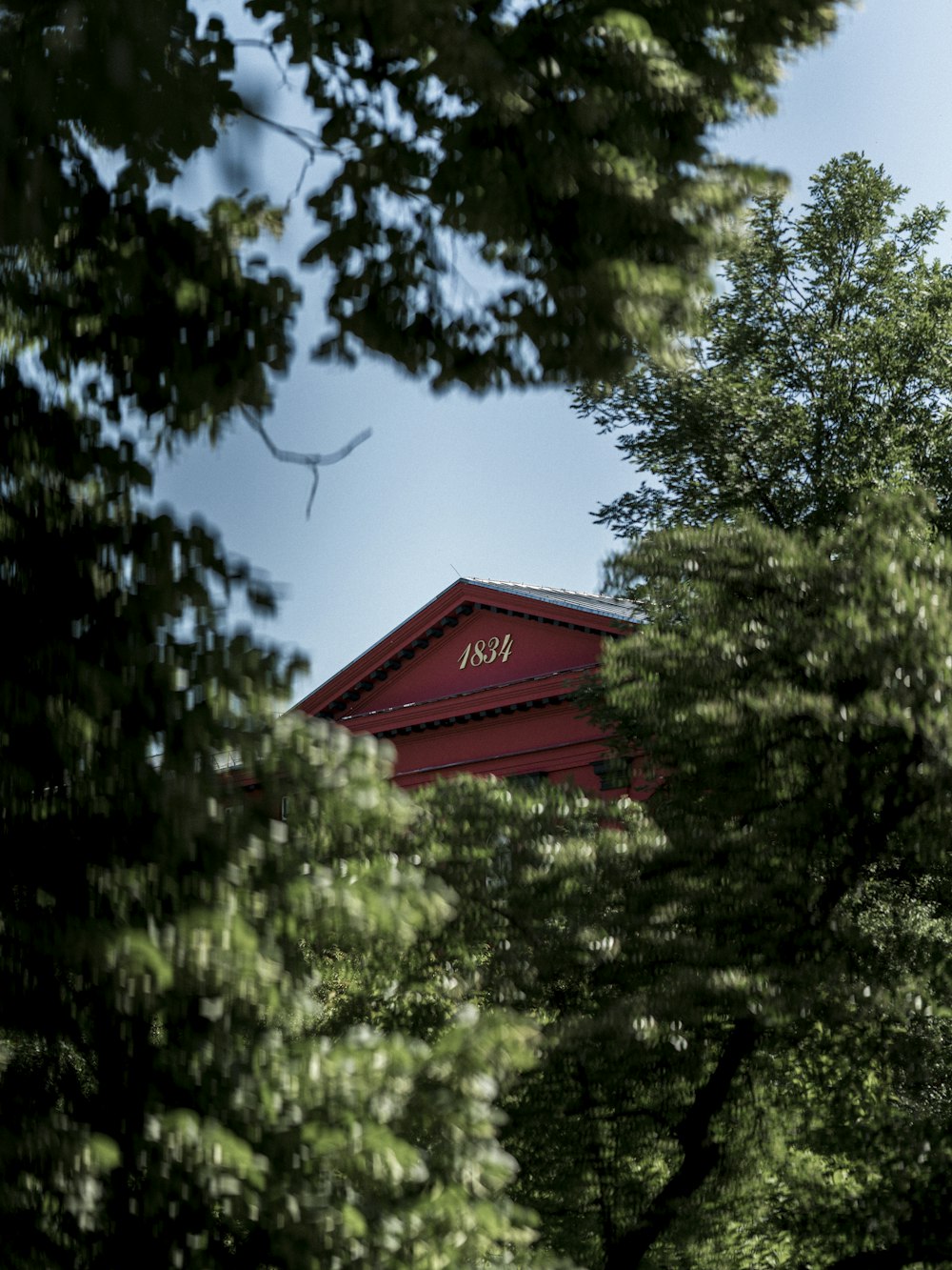 a red building surrounded by trees on a sunny day