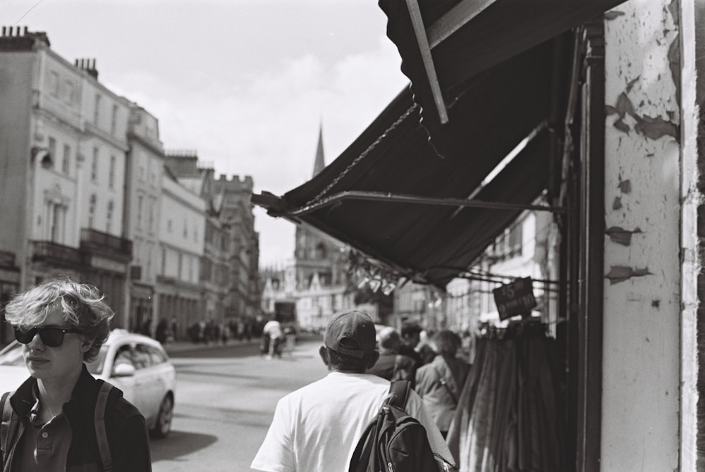 a black and white photo of people walking down a street