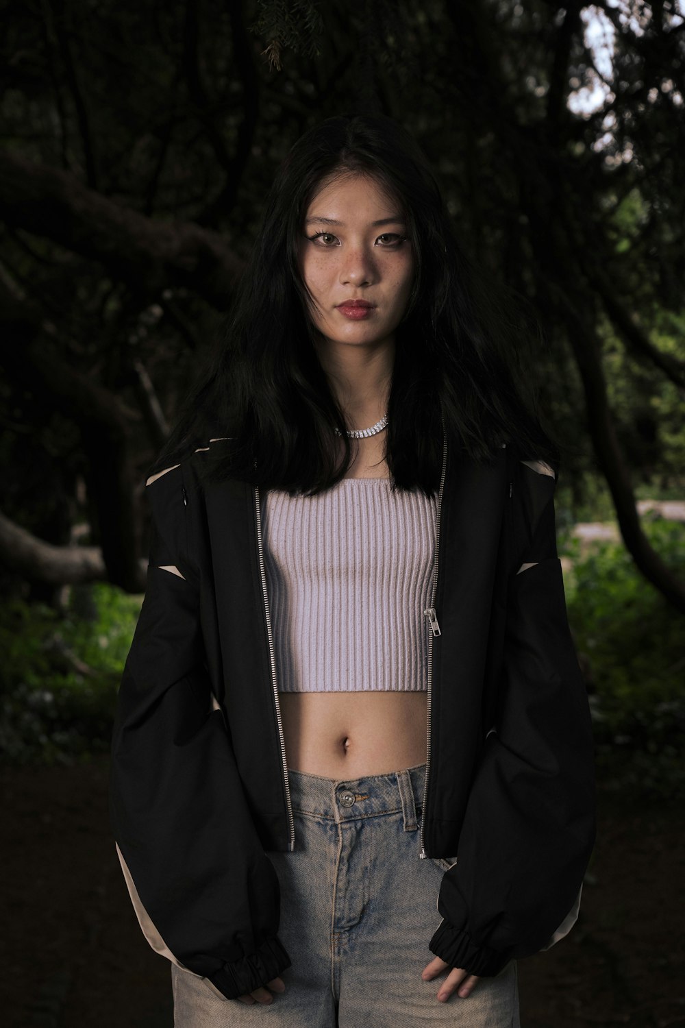 a woman standing in front of some trees