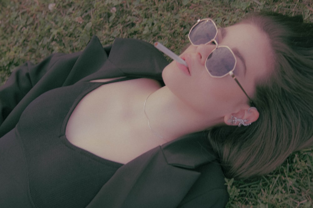 a woman laying on the ground wearing sunglasses