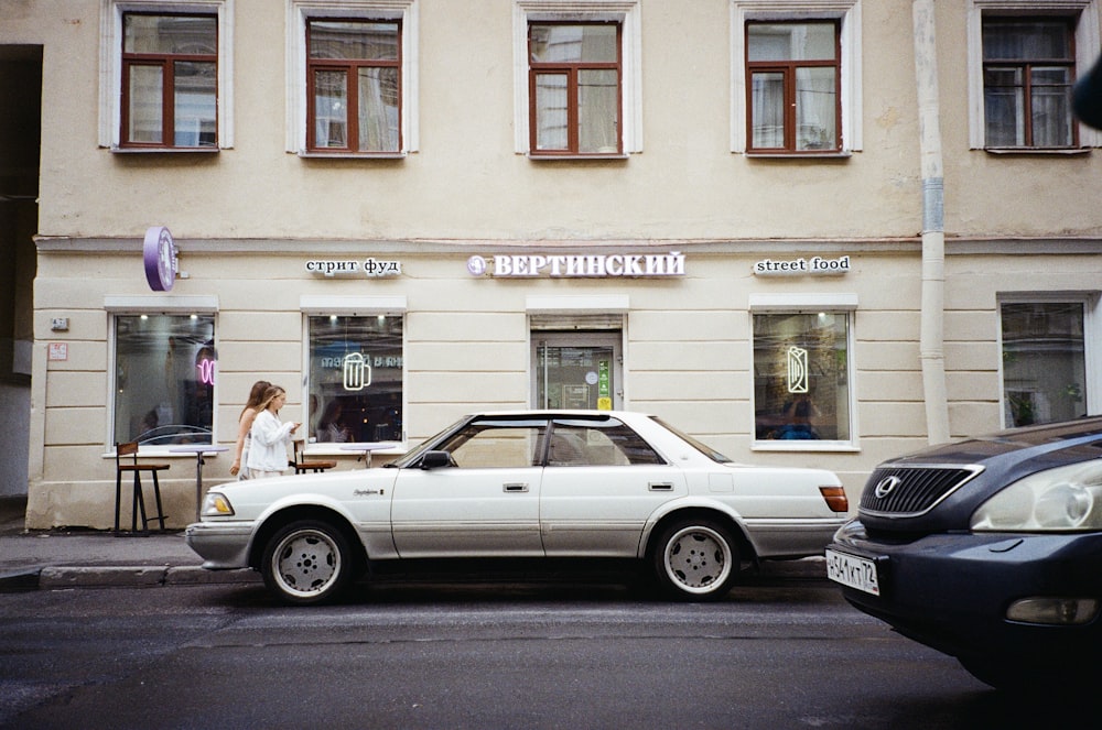 a white car parked in front of a building