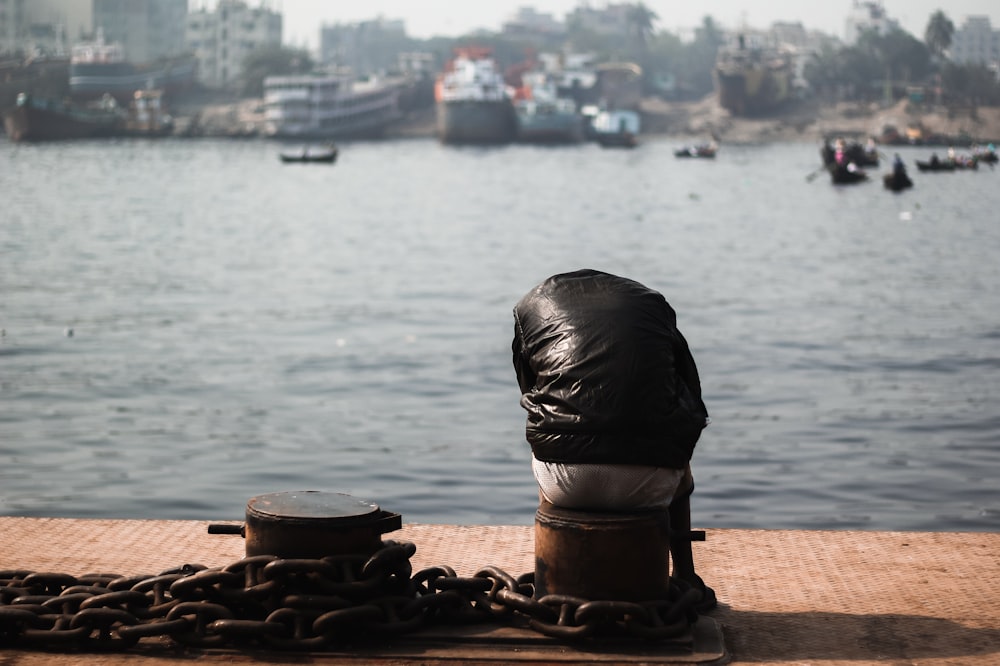 a person sitting on a dock near a body of water