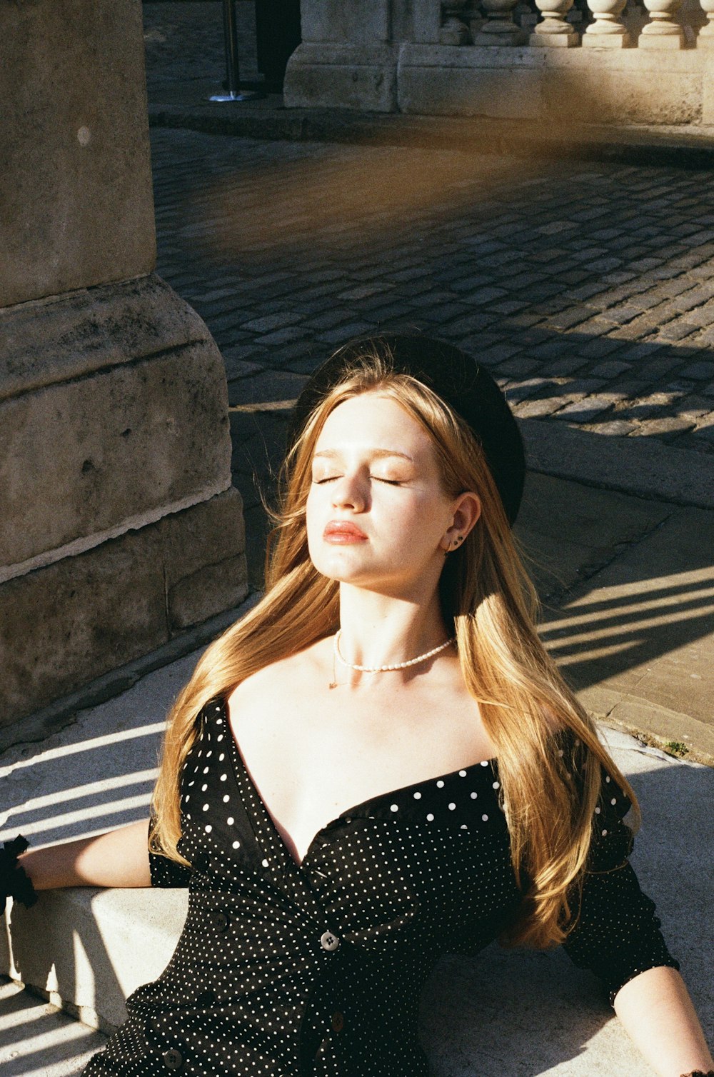 a woman sitting on the ground with her eyes closed