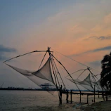 Colorful stilt fishermen casting nets against a golden sunset on the south coast.