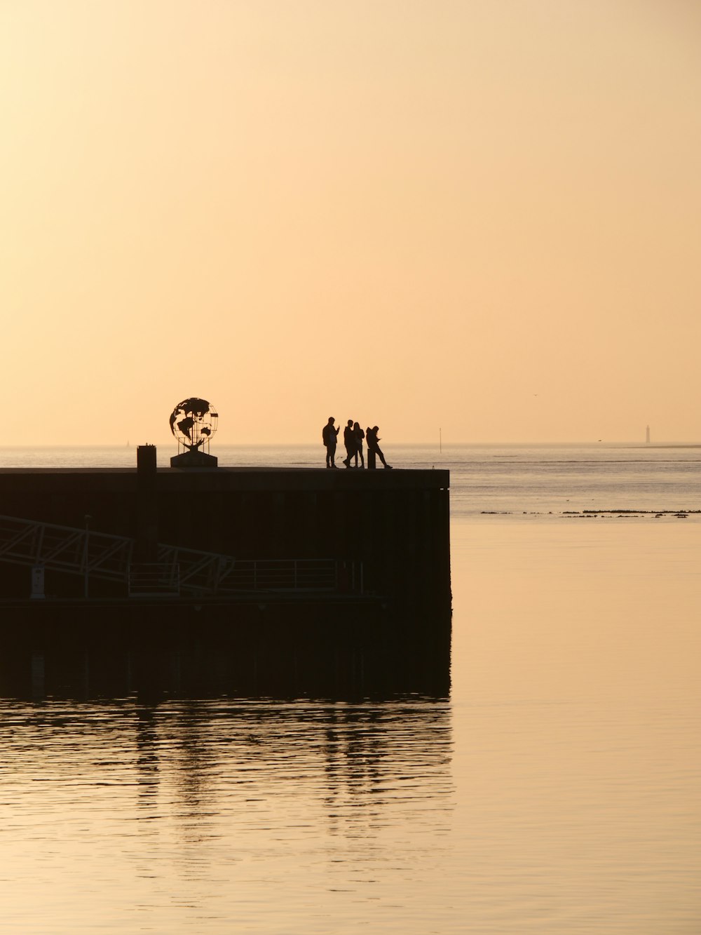 a group of people standing on top of a pier